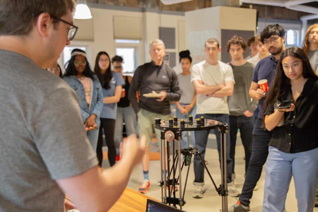 Man presents his technology prototype in front of gathered members of the Prototyping Hardware Accelerator