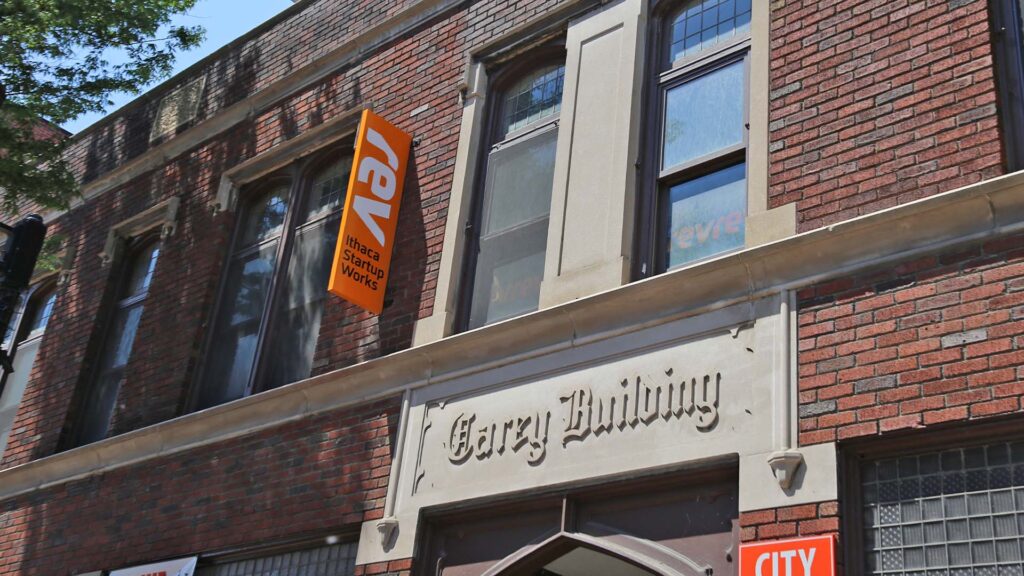 Outside of the Rev: Ithaca Startup Works building with orange Rev flag.